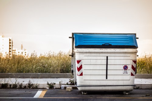 Workers loading construction waste into a skip